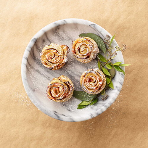 Rose shaped apple tarts in a marble dish.