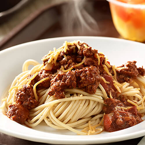 A hearty portion of spaghetti noodles, cheese and Cincinnati-style meat sauce, served in a white bowl.