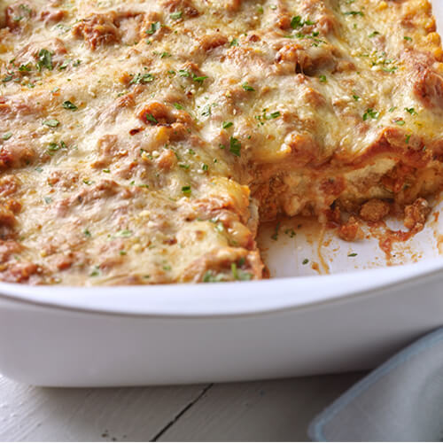 A classic turkey lasagna in a white baking dish.