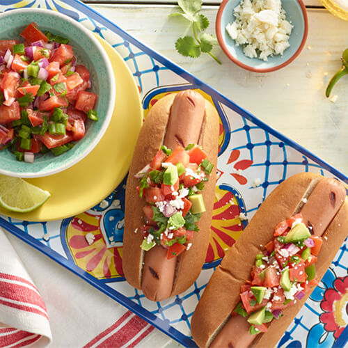 Fiesta turkey dog with salsa on a blue painted plate.