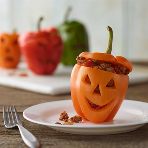 Halloween inspired taco stuffed turkey bell peppers with a jack-o-lantern face.
