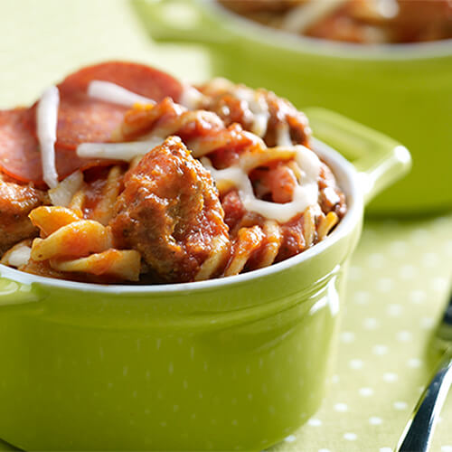 Rotini filled with pasta sauce, pepperoni, cheese, and ground turkey, all in a green pasta bowl.