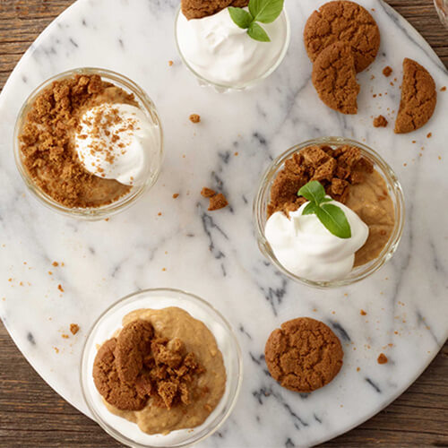 Pumpkin pie pudding with cookies and cream on a marble plate.