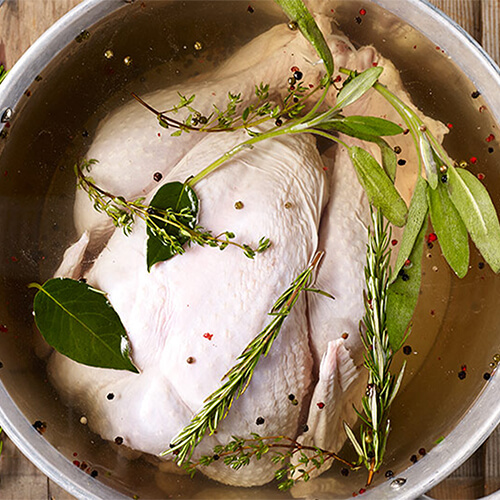 An herbed brine made in a large metallic pot.