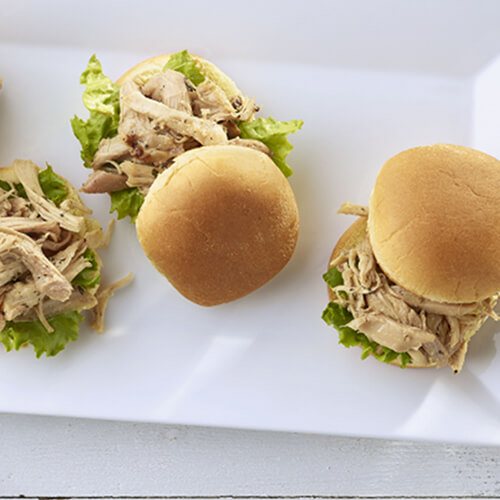 Shredded turkey sliders on a white plate.