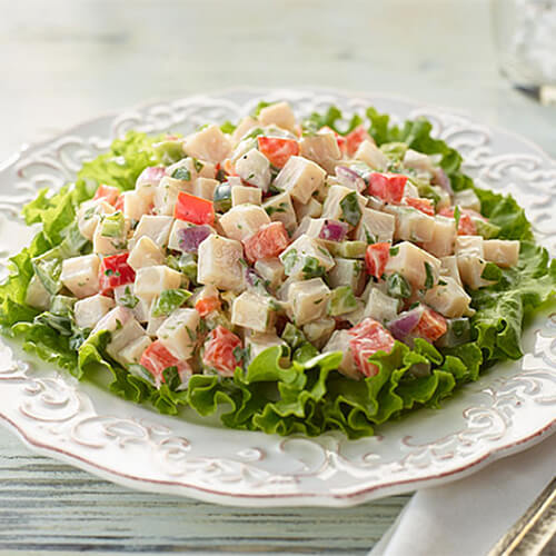 Southwest turkey salad in a white bowl on a wood table.