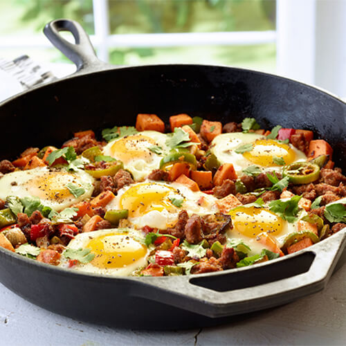 Southwestern turkey sweet potato breakfast hash garnished with green onions in a cast iron skillet.