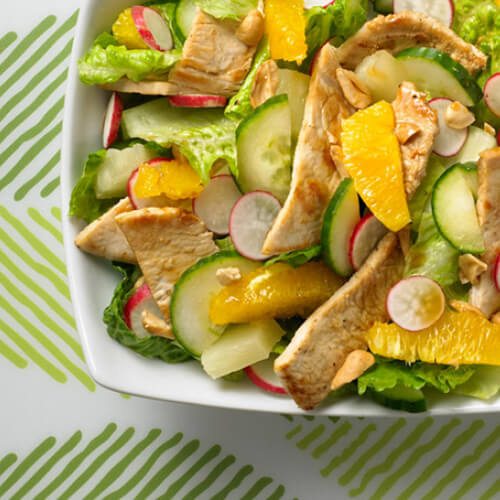Cooked turkey cutlets on a bed of romaine lettuce, pineapple, cucumber, oranges, radishes, and cashews, all mixed with honey and orange juice.