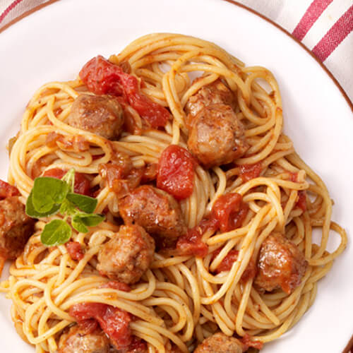 A curly pile of spaghetti with turkey meatballs and tomato sauce.