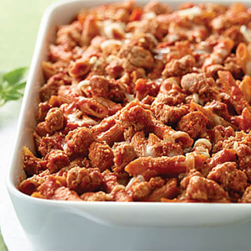 A ziti dish made from bolognese, savory lean ground turkey, and loaded with sautéed veggies, served on a white tray.