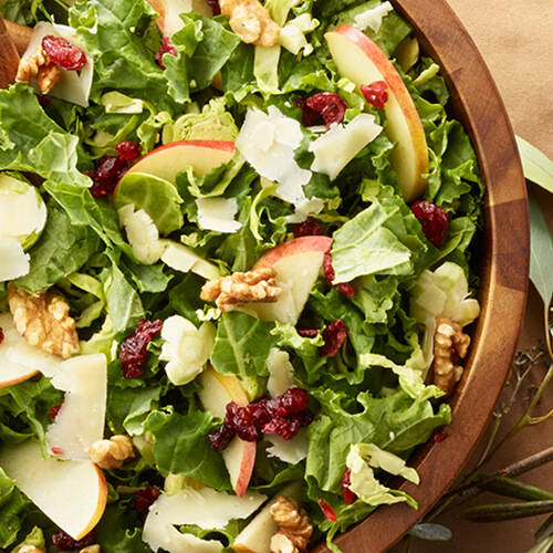 Turkey brussels sprouts and kale salad in a wood bowl.