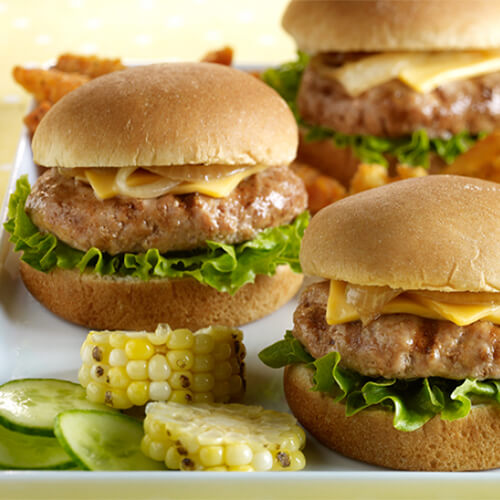Mini sliders filled with lettuce, onions, and cheese served with a variety of sides from corn to sweet potato fries.