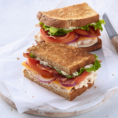 A crispy sandwich with turkey breast, crispy turkey bacon, vegetables and a dash of horseradish mayo.