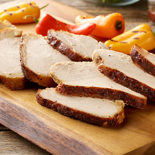 Turkey rub with grilled peppers on a wood cutting board.