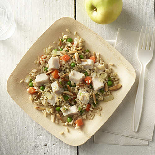 Chopped turkey breast on a bed of rice, carrots, and peas.